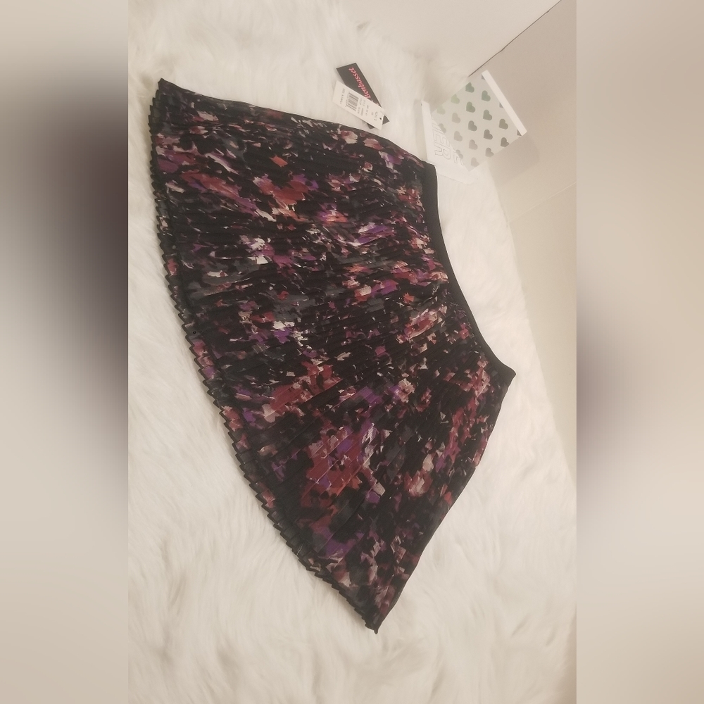 A short flower skirt. Its a size xs . It has very dark colors like black purple